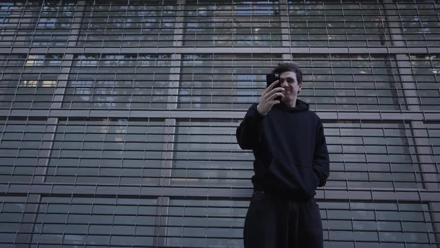 A man checks his phone on a windy day