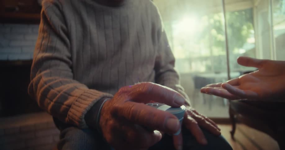 A man shows an elderly man how to use a controller for virtual reality