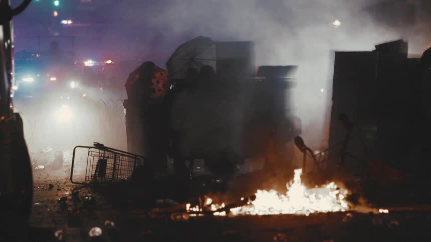 First responders deal with flaming debris and a smoking dumpster in the evening