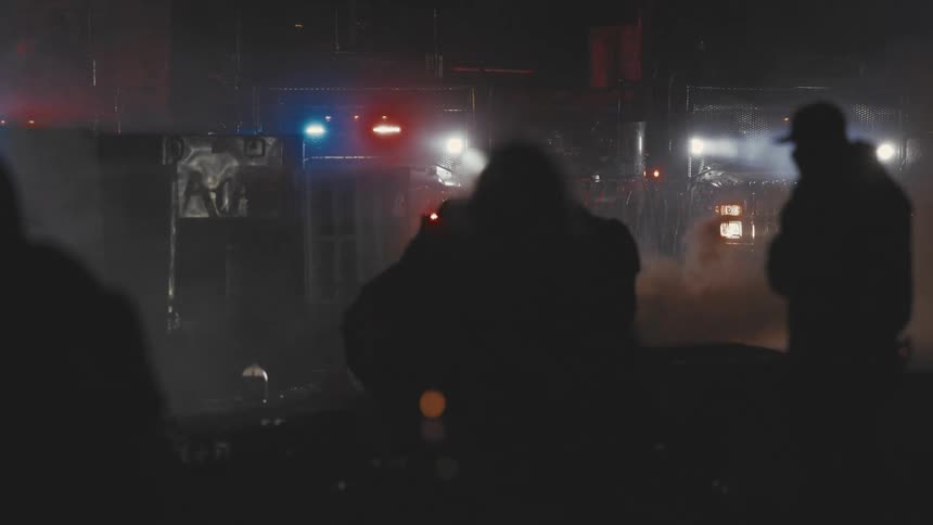 The injured protester is being helped through the smoke