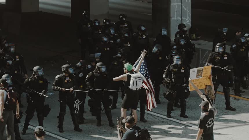 Protesters are being pushed back by a crowd of police