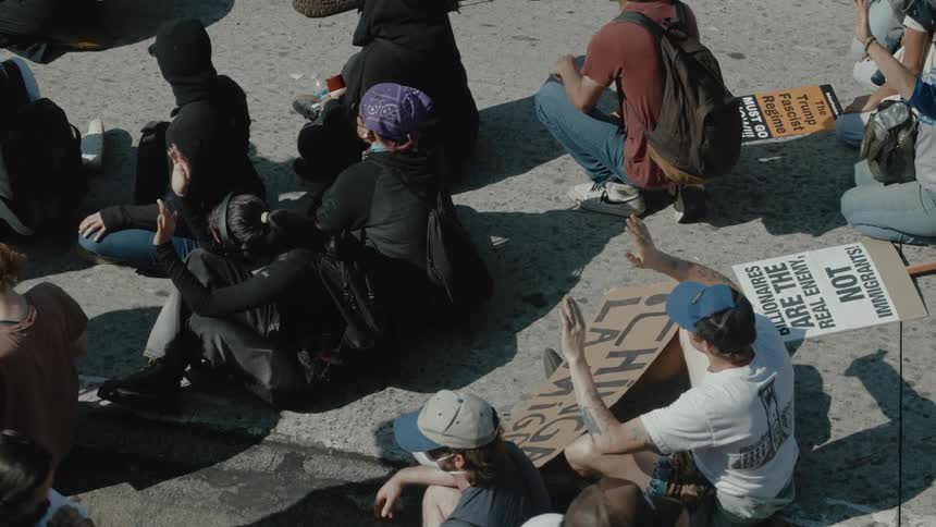 Protesters are detained and sitting on the ground