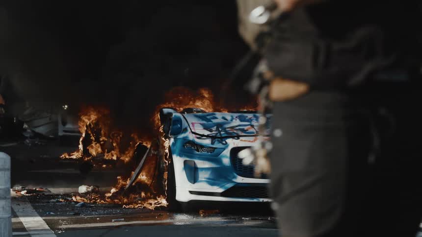 A burning car covered in graffiti