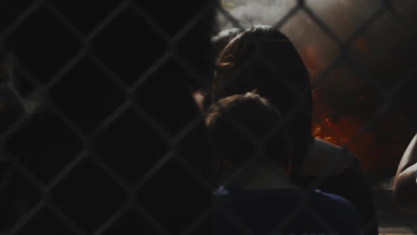 Protesters watch as the car burns