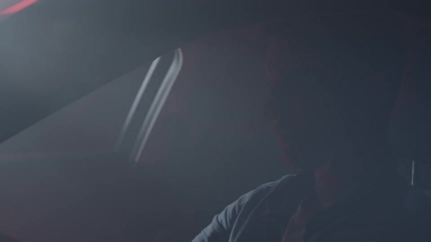 A young man is riding as a passenger in a car