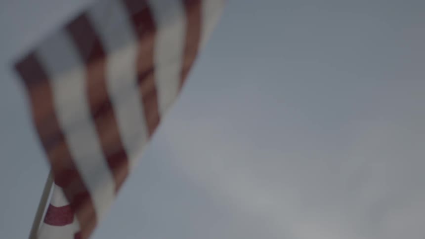 An american flag is held up as it billows in the wind