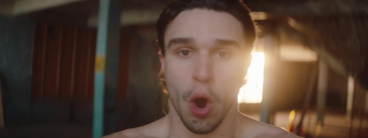 A shirtless man yelling angrily his facial expression intense and his body tense as he expresses frustration
