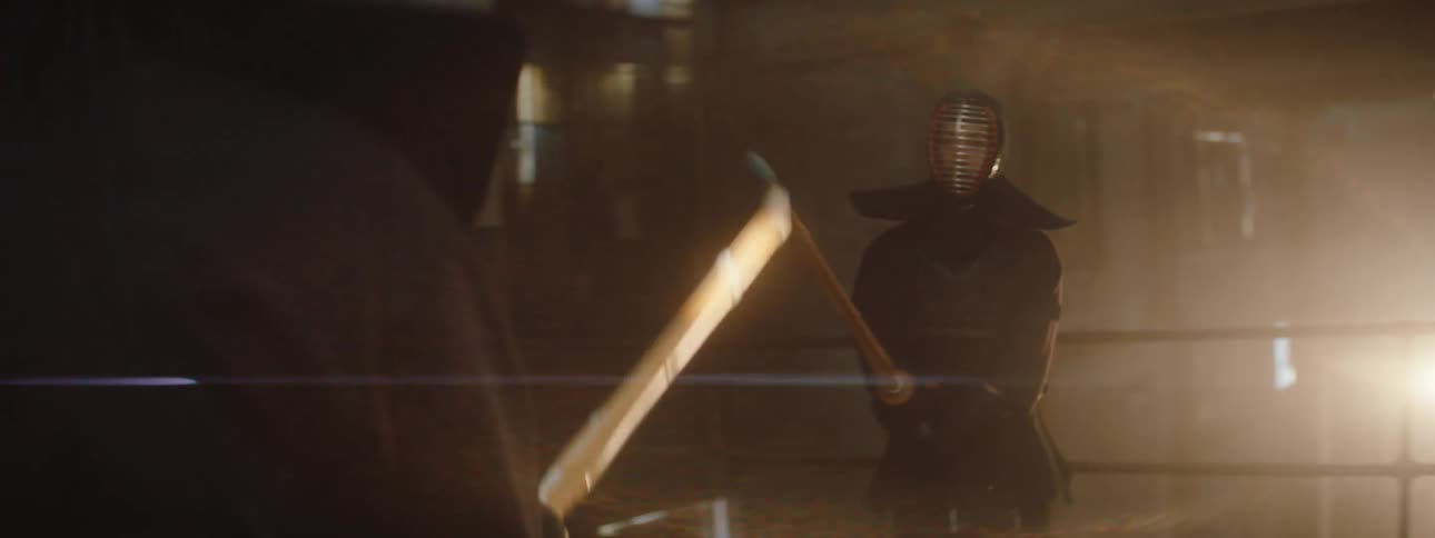 Two kendo practitioners in full protective gear clash with bamboo swords in a dimly lit room lit by streaks of shifting light