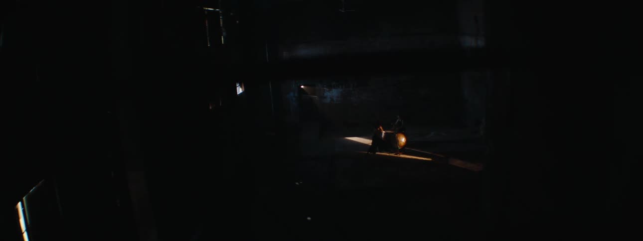 Silhouette of two people inside a shed