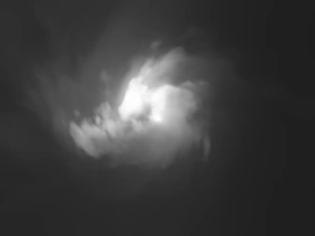 A cloudy sky transitioning from a bright sunny day into the darker hues of nighttime