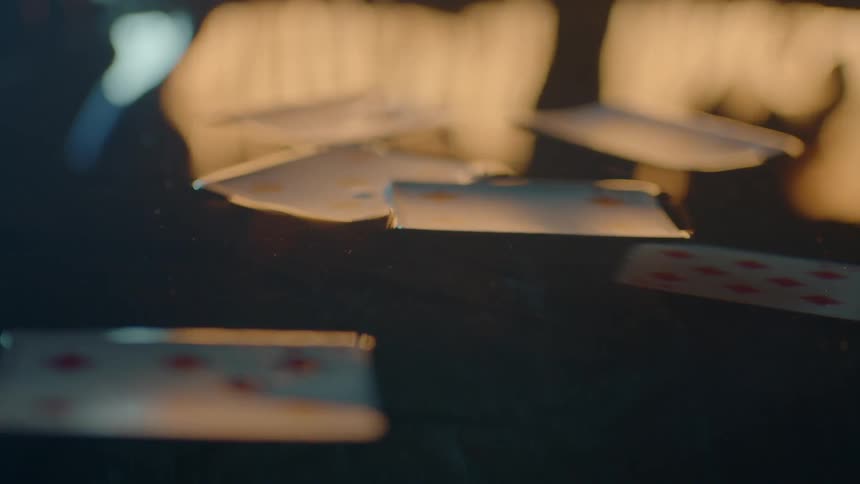 Cards sit in the water with a flame in the distance