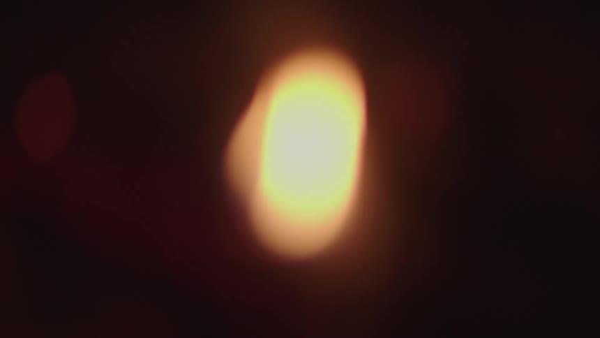 A small flame of fire in a campfire in a dark outdoor environment