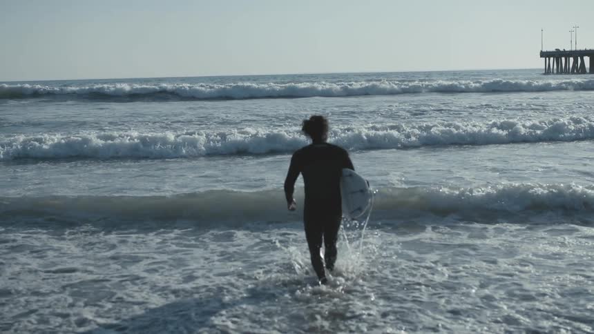 A person walking into the ocean