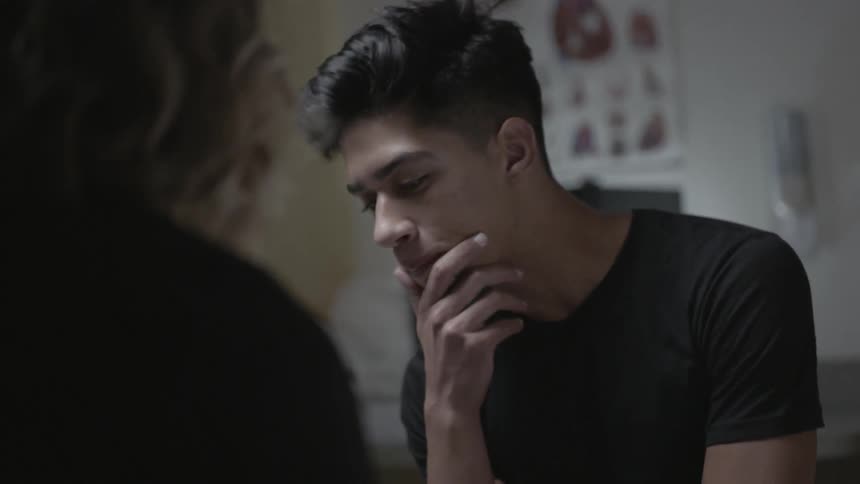 A young man contemplates during a conversation
