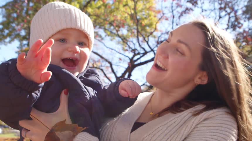 Mother with small child on her lap in a backyard