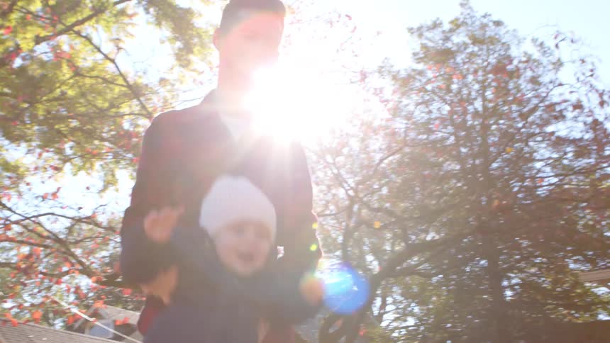 Father playing on a slide with his little son