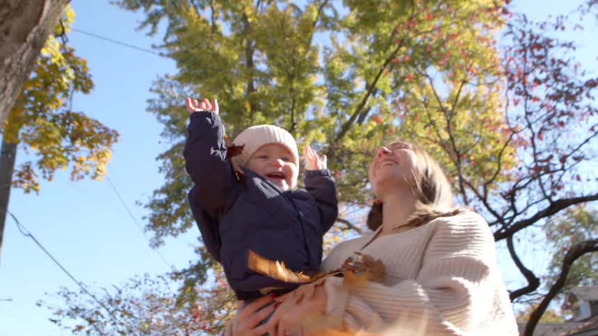 Leaves are thrown on a mother and her son