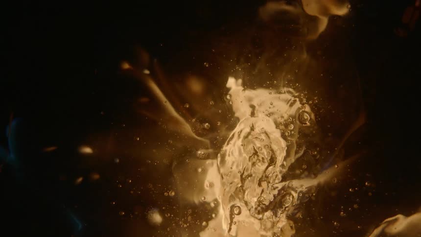 A puddle of water undulates and reflects lights
