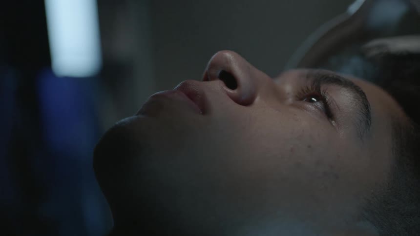 A man is lying down and staring straight up