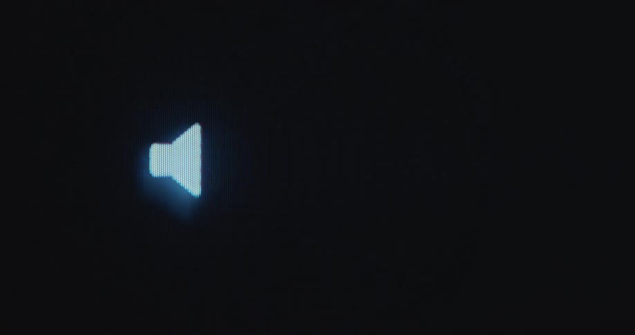 White loud speaker or volume icon or emoji is displayed on a pixelated computer screen with the sound increasing as a visualization for music through moving soundwaves created by digital audio equipment