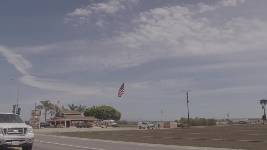 Commercial establishment with flags on the side of a highway