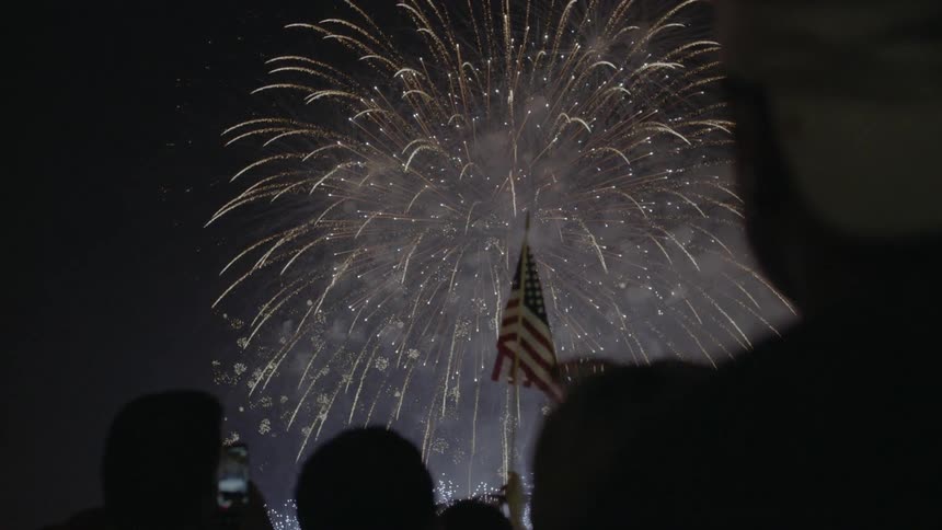 A crowd watches a fireworks display