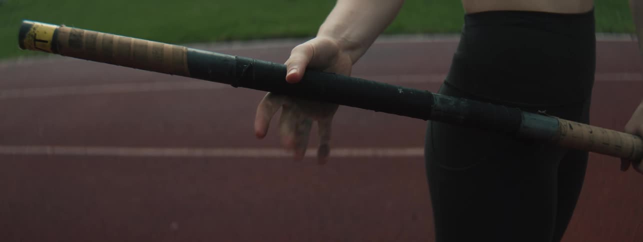 A pole vaulter is standing on the track