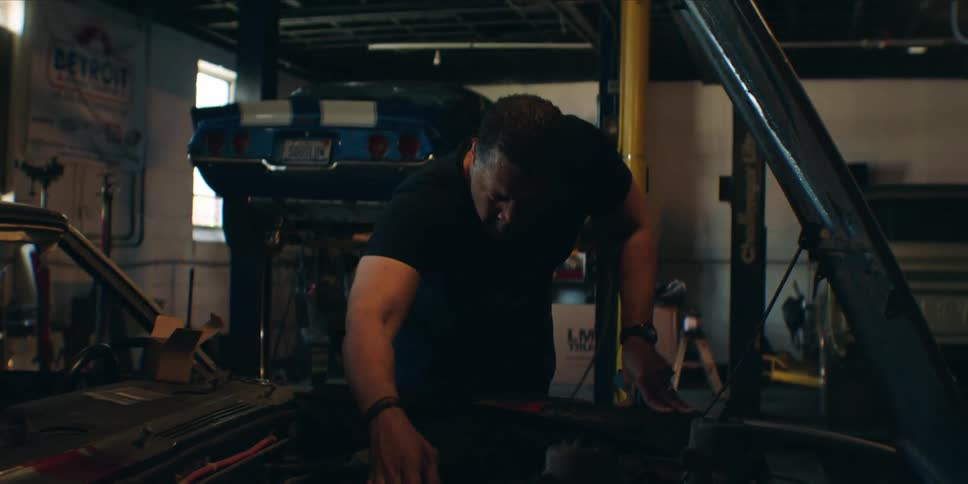 Mechanic working on a vehicle engine in a garage