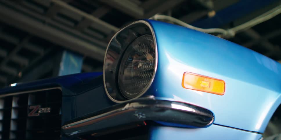 A close up of the front corner of an old blue car