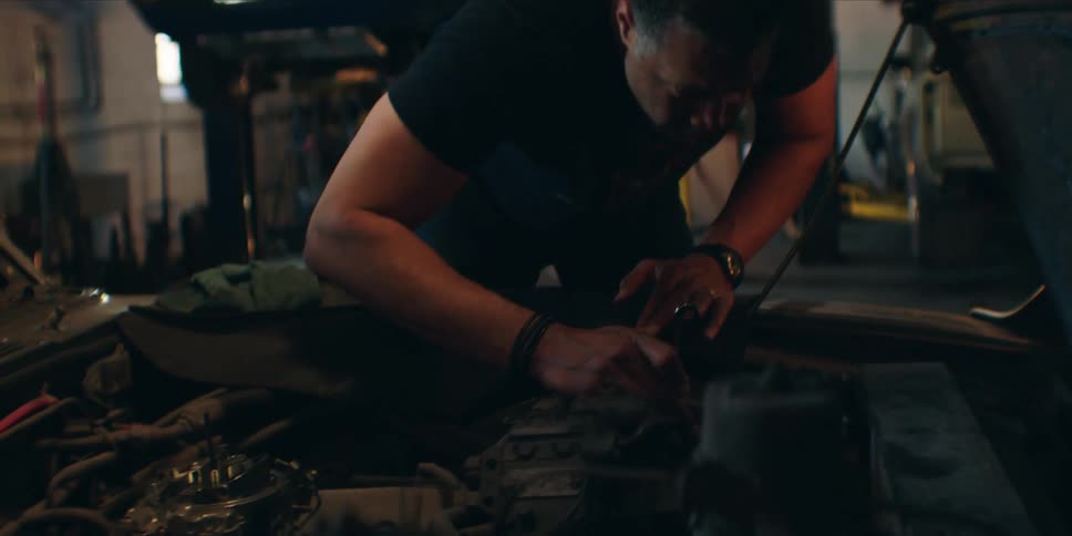 The mechanic is working on the car engine
