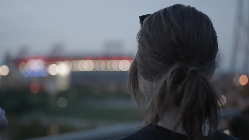 A woman stares out over a railing