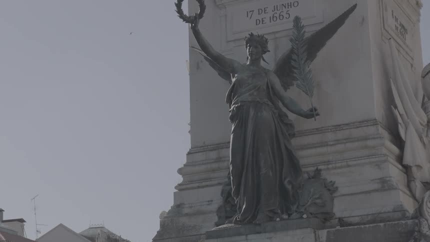 A statue stands in a city on a sunny day