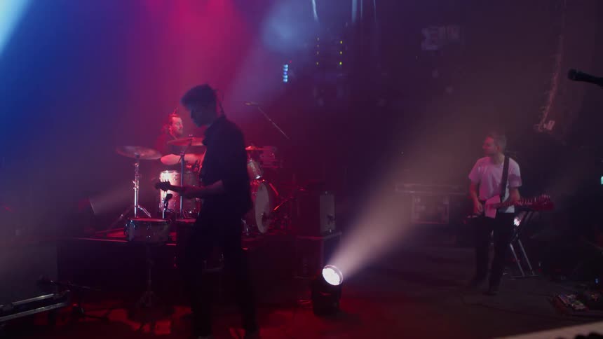 Band performing in an auditorium with studio lighting