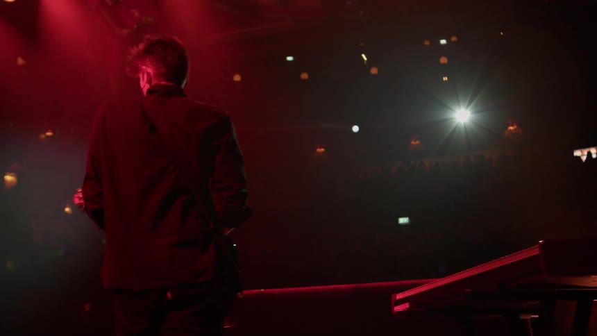 The guitarist walks around the stage playing