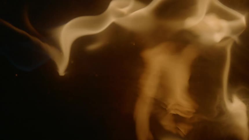 A fire is blazing in a dark area