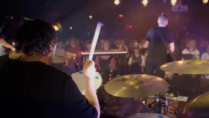 A drummer playing drums at a rock concert