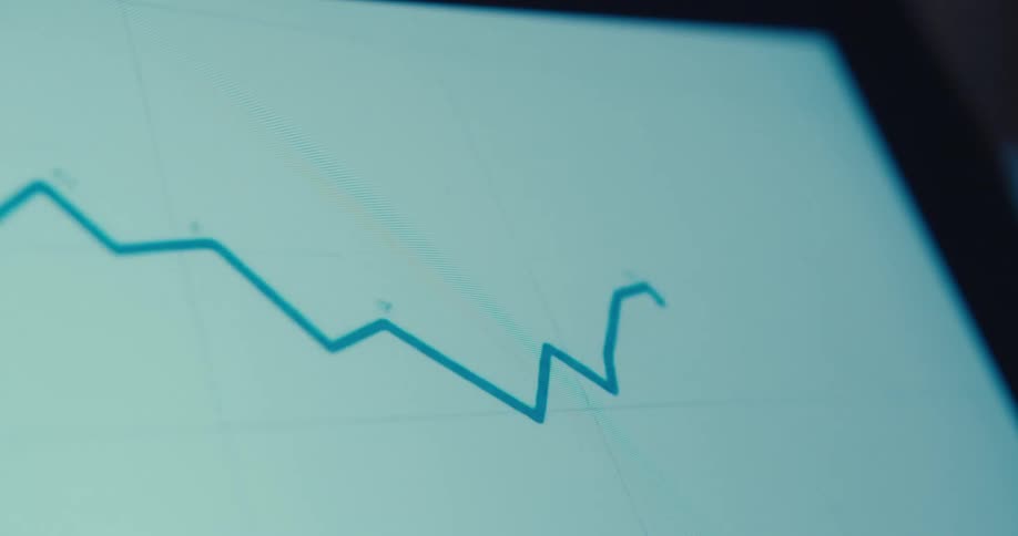 A fluctuating line graph appears on a digital screen with distinct peaks and troughs