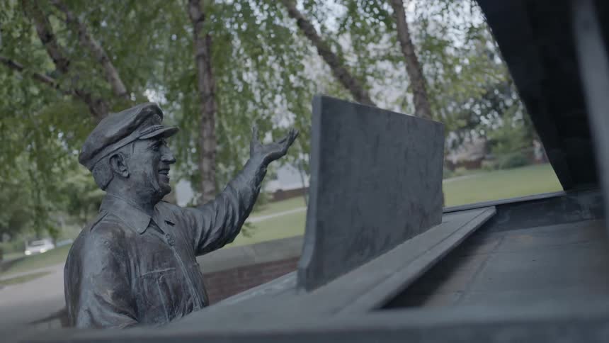 An outdoor statue of a man sitting at a piano