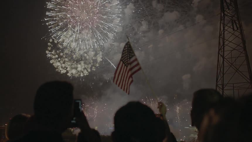 People look on as fireworks explode in the sky