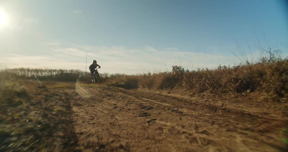 Dirtbiker races by while doing a wheelie