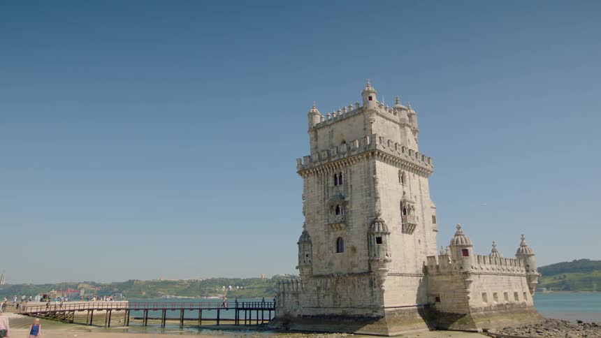 A tall tower sits by the water on a sunny day