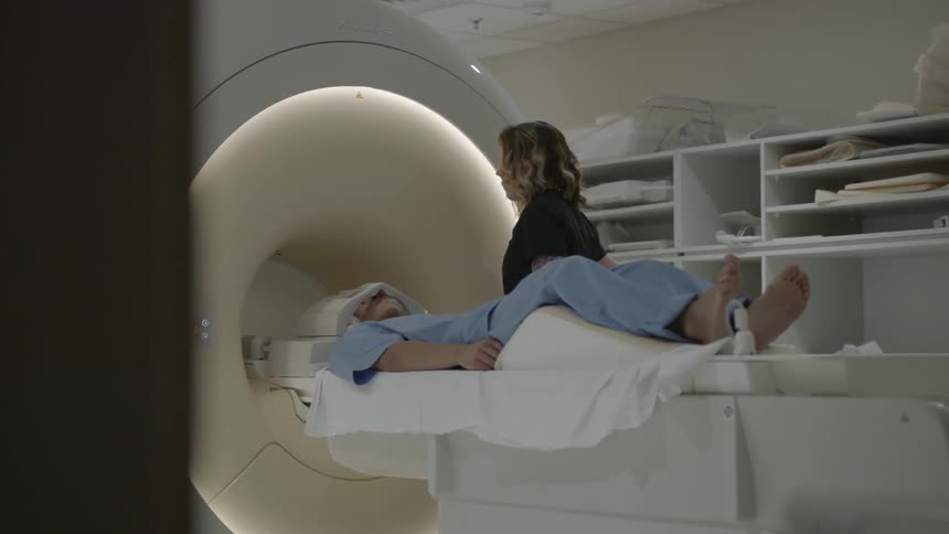 A woman stands near a patient waiting for an mri