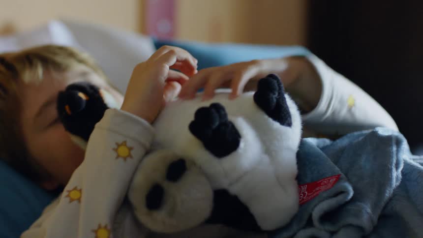 Boy sleeping hugging a teddy bear