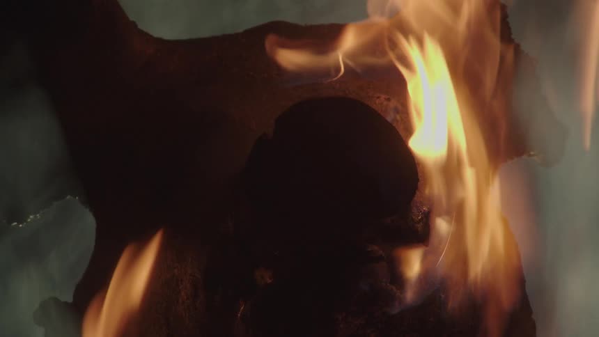 A charred pig head engulfed in fire and flames
