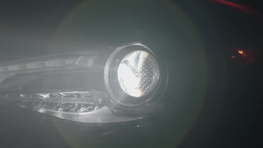 The headlight of a car is lighting a dark area