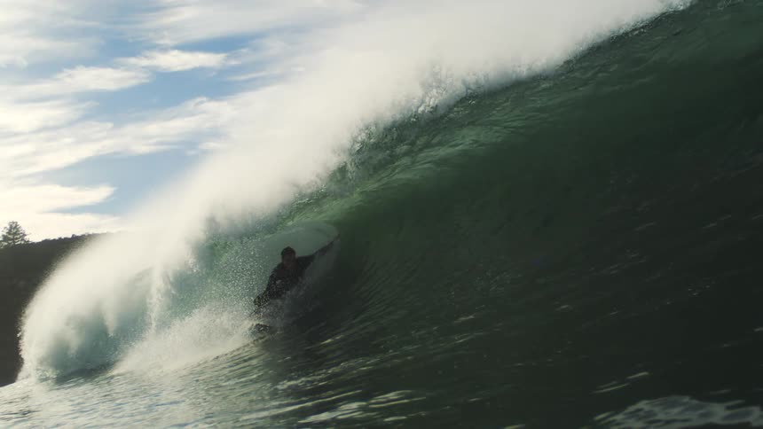 Surfer rides inside a powerful curling wave