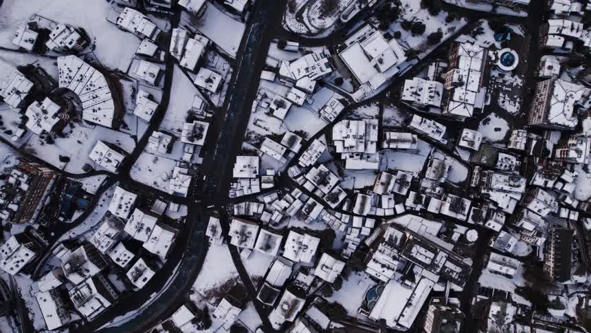 Aerial view of a city residential area blanketed in snow at midday