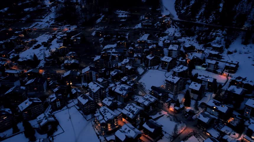 A town is covered in snow at night