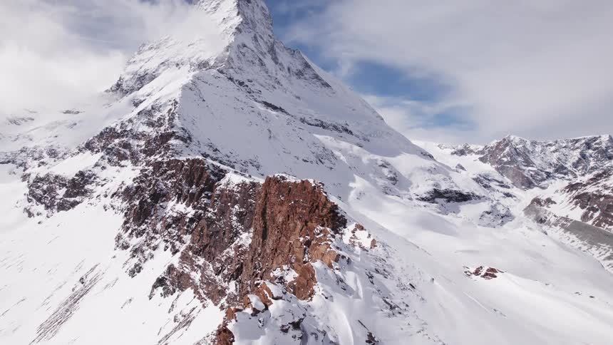 A large snowy mountain with an even higher peak
