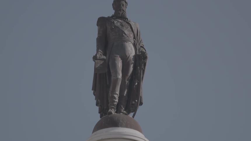 A statue stands atop a pillar
